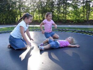 Kinder auf einem Kindertrampolin.